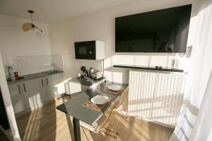 a kitchen with a table and a tv on the wall at Relax studio in Le Mée-sur-Seine