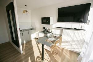 a living room with a table and a flat screen tv at Relax studio in Le Mée-sur-Seine