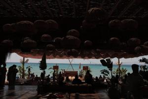 a group of people on a beach with the ocean at @before sunset in Çeşme