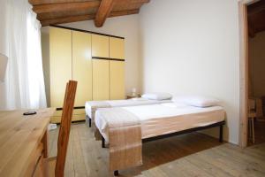 a room with two beds and a desk at La Casa nel Borgo in San Pietro in Casale
