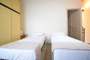 two twin beds in a room with a door at La Casa nel Borgo in San Pietro in Casale +10 photos