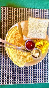 a plate of food with pancakes and a sandwich at Hotel Tree Tops in Sauraha
