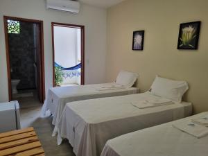two beds in a room with a window at Pousada Prazeres do Velho Chico in Belo Monte