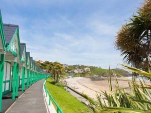 a walkway next to a beach with green buildings at Pass the Keys Cosy Flat in Maritime Quarter in Swansea