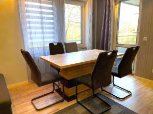 a wooden table and chairs in a room at Bina Familienapartment Trier in Trier
