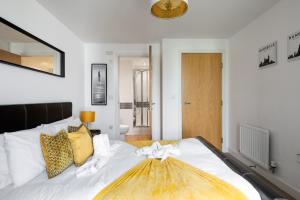 a bedroom with a large white bed with a bow on it at Modern 2 bed in central MK, Free Parking, Smart TV in Buckinghamshire