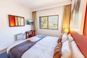 een slaapkamer met een bed en 2 ramen bij Lantern 1 Bedroom Balcony with alpine view in Thredbo