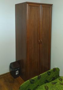 a wooden cabinet in a room with a green couch at Hostel Reja 54A in Suwałki
