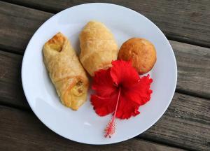 un piatto di alimenti con un fiore rosso e un prodotto da forno di Gold Coast Inn - Adults Only a Nanuya Lailai