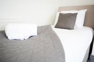 a bedroom with a large bed with white sheets and pillows at Sherlock House - Stylish Home Sleeping up to 6 in Wallasey