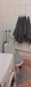 a bathroom with a toilet and a rack of towels at Hostel Reja 54A in Suwałki