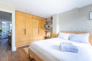 Säng eller sängar i ett rum på Rustic Modern 1BD Flat wGarden Stoke Newington!