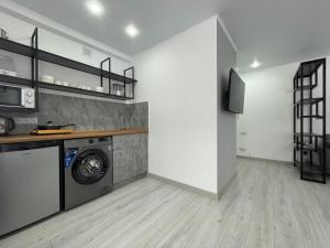 a laundry room with a washing machine and a tv at 1-комнатная квартира в самом центре города. Центральный парк in Petropavlovsk