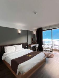 a bedroom with a large bed and a balcony at Roxana Sapa Hotel - by Bay Luxury in Sa Pa
