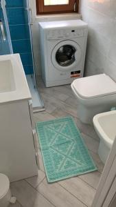 ein Badezimmer mit einem WC und einer Waschmaschine in der Unterkunft Villino Mimosa in Costa Rei