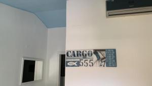 eine Wand mit einem Bild von einem Schild darauf in der Unterkunft Villino Mimosa in Costa Rei