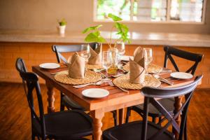 une table en bois avec des chaises et une table pour un repas dans l'établissement Kara O Mula Mulanje, à Mulanje