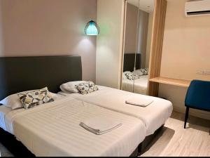 Habitación de hotel con 2 camas y espejo en Seaview Mercure Hotel Suite KK City Center, en Kota Kinabalu