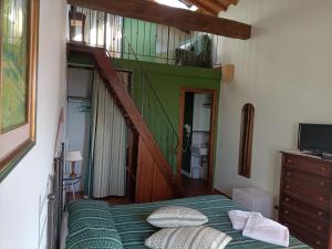 a bedroom with a bed with a green comforter at Agriturismo Scannano in Serre di Rapolano