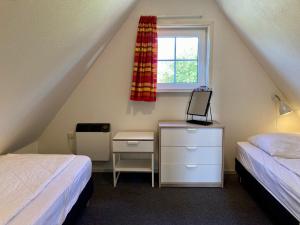 a attic bedroom with two beds and a window at Heide 6pers Waterfront house at a typical dutch canal, by the Lauwersmeer in Anjum