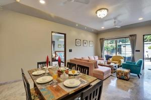 a living room with a table and a couch at ELIVAAS Radhyam Luxe 2BHK Villa with Pvt Pool in Udaipur