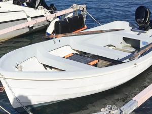 4 person holiday home in ELL S في Ellos: قارب أبيض مربوط بمرسى في الماء