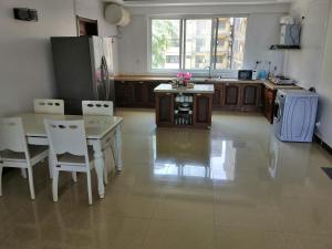 a kitchen with a table and chairs and a refrigerator at Blessie Ocean View Home in Dar es Salaam