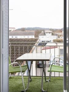 uma mesa e duas cadeiras numa varanda em Residence Louis Quartier Centre Ville em Vittel