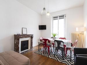 uma sala de estar com uma mesa e cadeiras e uma lareira em Residence Louis Quartier Centre Ville em Vittel
