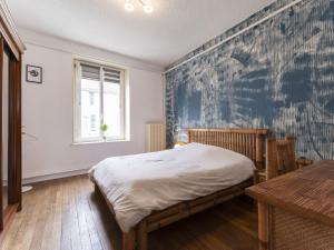 1 dormitorio con cama y pared azul en Residence Louis Quartier Centre Ville en Vittel