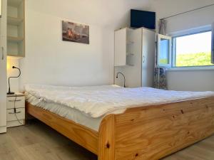 a bedroom with a wooden bed and a window at am Deich 6 pers House with a private terrace behind a dike by the Lauwersmeer in Anjum