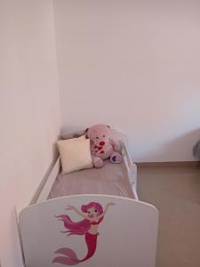 una cama con un osito de peluche sentado en ella en Apartman SARA, en Vršac