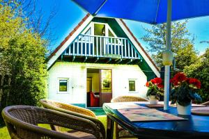 AnjumにあるNatascha 6pers House Near Lauwersmeer National Parkの家の前にテーブルと椅子、傘