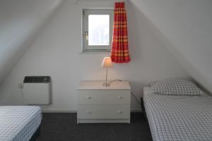 AnjumにあるNatascha 6pers House Near Lauwersmeer National Parkのベッドルーム1室(ツインベッド2台、窓付)