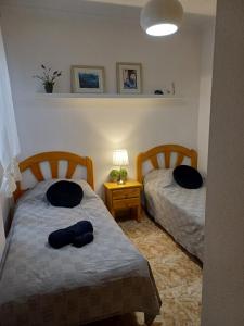 a bedroom with two beds and a table with a lamp at Playa del Cura apartment with a free parking place in Torrevieja