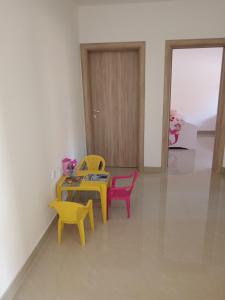 Zimmer mit einem Tisch, 2 Stühlen und einer Tür in der Unterkunft Apartman SARA in Vršac