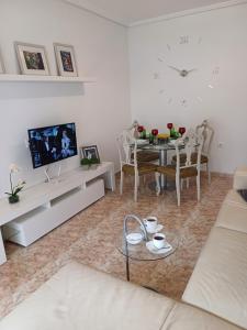 sala de estar blanca con mesa y TV en Playa del Cura apartment with a free parking place, en Torrevieja
