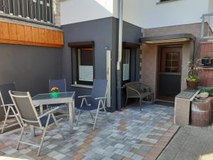 a patio with a table and chairs and a building at Ferienwohnung Am Wald in Catterfeld