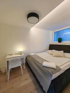 a bedroom with a bed and a table and a window at Haas Apartments Slepa, city centre, parking, courtyard in Brno