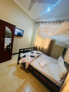 una camera con un letto e una finestra con televisore di Peacefully Resort a Dodoma