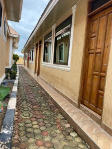 a stone walkway next to a building with a door at Peacefully Resort in Dodoma