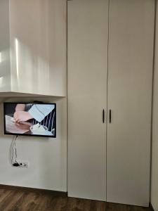 een woonkamer met een tv en een witte kast bij ALLtina apartments 2 in Belgrado