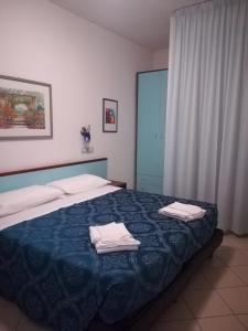 a bedroom with a bed with towels on it at Residence Oltremare in San Benedetto del Tronto