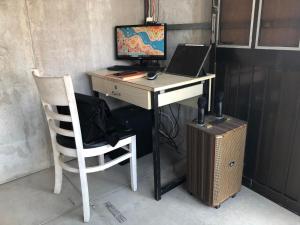 a desk with a computer and a chair with a computer on it at Cactos Bar & Homestay in Ho Chi Minh City