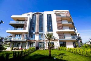 un edificio blanco con una palmera delante en Luxury Duplex With Wonderful View In Izmit, en Çavuşçiftliği