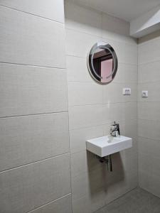 een badkamer met een wastafel en een spiegel bij ALLtina apartments 2 in Belgrado