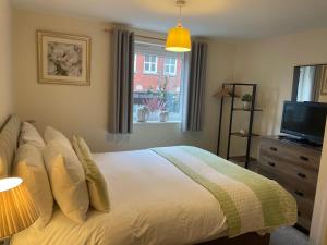 a bedroom with a bed with a television and a window at Number 10 Serviced Apartment - Chapel in Southampton