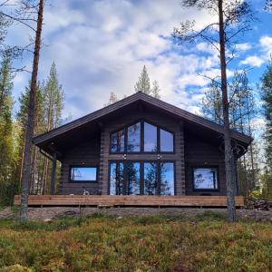 Cabaña de madera en el bosque con ventana grande en Villa Sol Del Luosto, en Luosto