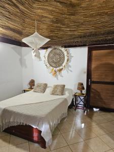 ein Schlafzimmer mit einem Bett und einem Kranz an der Wand in der Unterkunft Auberge Keurmariguen in Somone