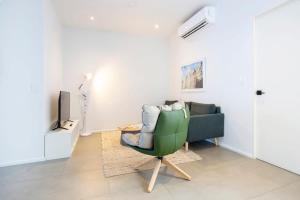a living room with a green chair and a tv at Artistic 2BR With Pool In Casco Antiguo in Panama City